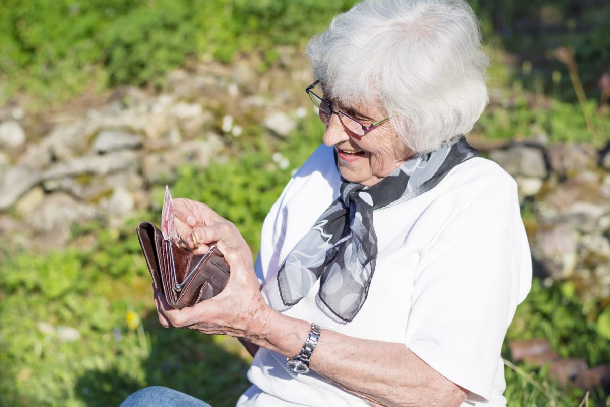 idosa verifica o dinheiro em sua carteira