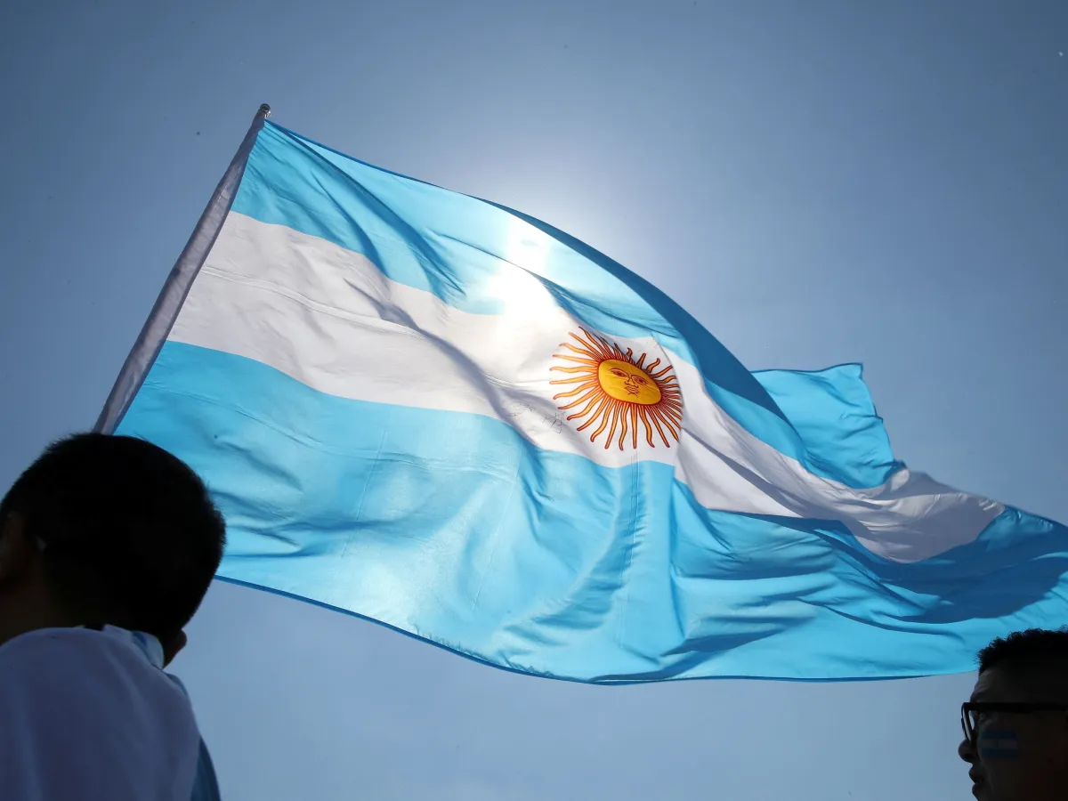 Imagem da bandeira da Argentina com o céu azul atrás