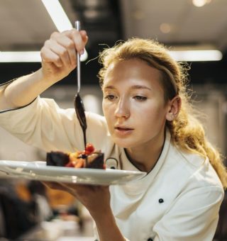 Auxiliar de cozinha montando prato para receber salário