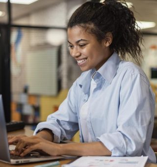 Estudante trabalhando pelo notebook em uma empresa