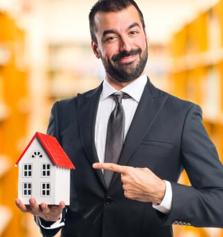 Homem de negócios segurando miniatura de casa