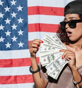 Garota na frente da bandeira dos EUA com salário mínimo em dólar na mão