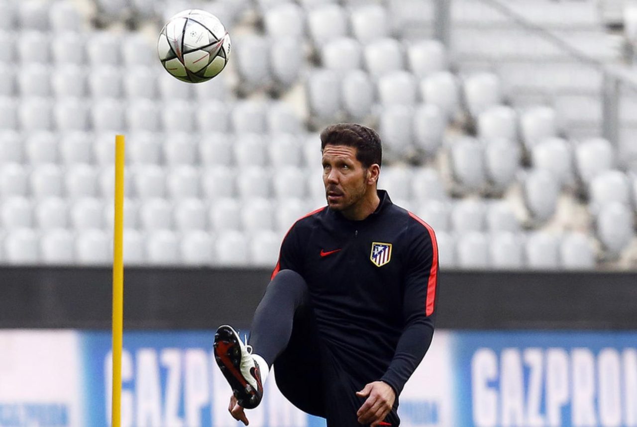 Técnico Diego Simeone chutando bola durante treino